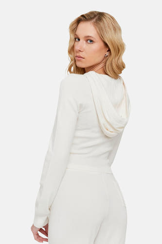 Cardigan beige de TALLY WEIJL, avec des manches longues et un capuchon, porté avec une jupe coordonnée.