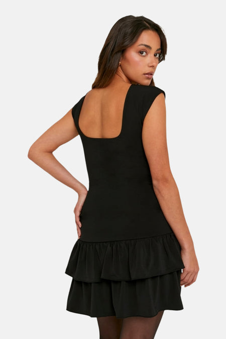 Zwarte jurk met vierkante hals en geplooide rok.