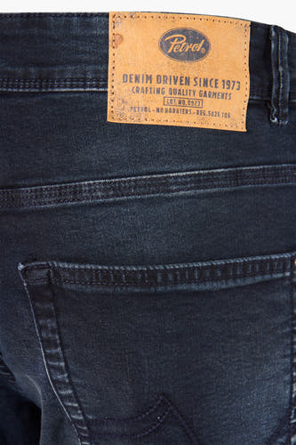 Jean slim fit bleu marine de Petrol Industries, avec un lavage vintage et une étiquette en cuir.