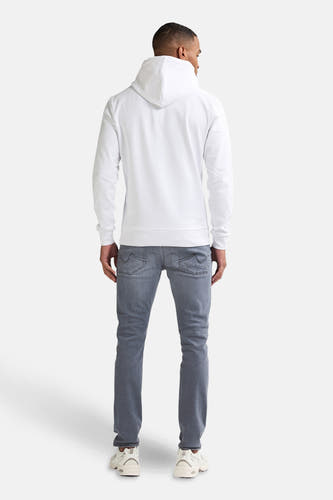 SEAHAM jeans denim clair slim de Petrol Industries, avec des poches arrière brodées et des baskets blanches.