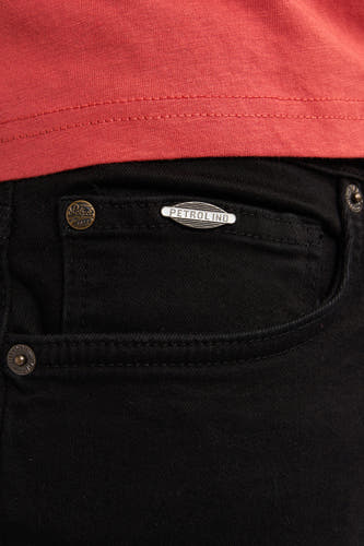 Jean slim noir de Petrol Industries avec badge de marque et pièce de monnaie.
