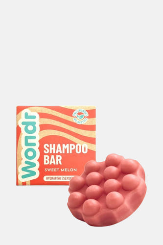 Shampooing barre rose de WONDR CARE, avec un emballage en carton à motif ondulé.