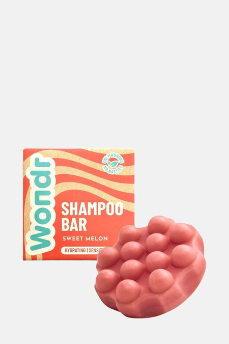 Shampooing barre rose de WONDR CARE, avec un emballage en carton à motif ondulé.