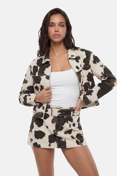 Veste courte à imprimé vache beige et marron de TALLY WEIJL, avec fermeture éclair, portée sur un haut blanc avec une mini-jupe assortie.
