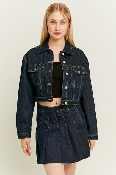 Blouson de jeans bleu marine de TALLY WEIJL, porté avec une jupe coordonnée et un crop top noir.