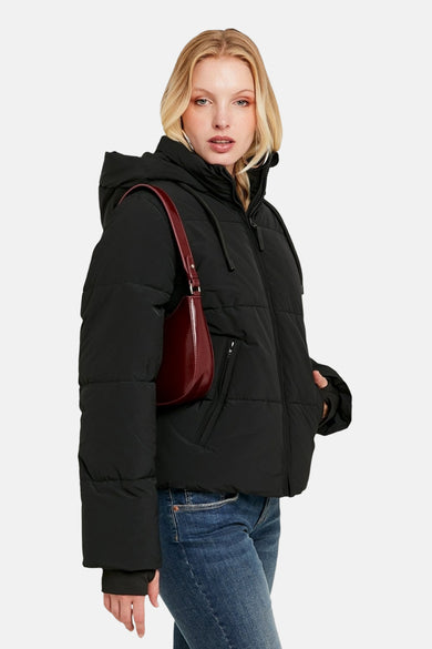 Manteau court noir de TALLY WEIJL, avec capuche, poches sur les épaules rouges et jeans bleus.