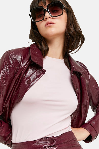 Manteau de couleur bordeaux en cuir imitation TALLY WEIJL, avec une texture brillante et une fermeture à boutons.