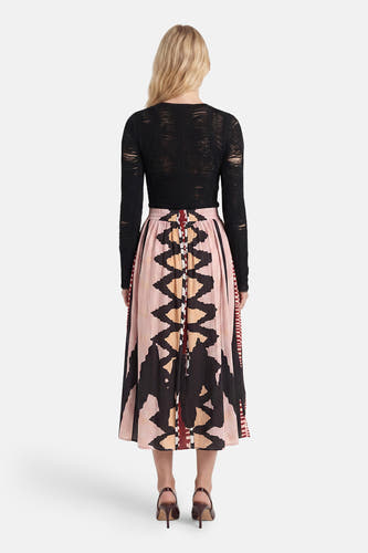Multicolor lange rok met geometrisch patroon van ADORE, getoond van achteren met zwarte mesh top en bruine hakken