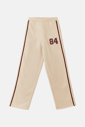 Jean de jogging beige TALLY WEIJL avec une ceinture marron sur le côté et le numéro 84.