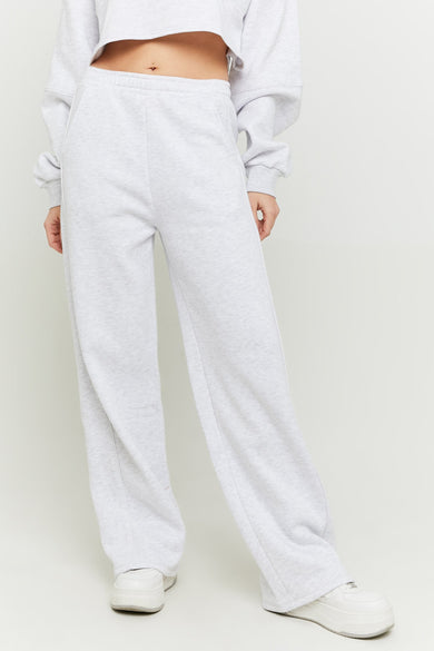 Jean de jogging gris TALLY WEIJL, avec des jambes larges et porté avec un pull court et des baskets blanches.