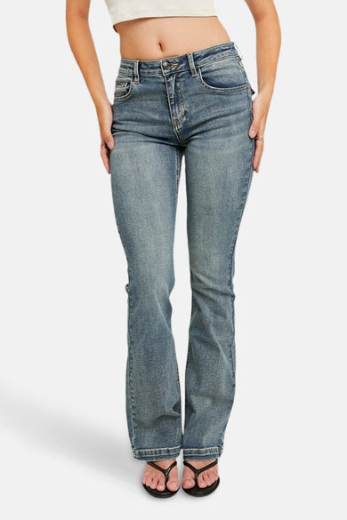 Jean bootcut bleu de TALLY WEIJL, avec une taille moyenne et porté avec des chaussons noirs.