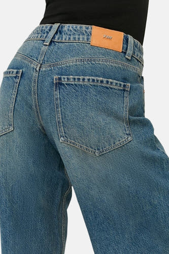 Jean en denim bleu clair à jambes larges de TALLY WEIJL, poches arrière, patch de marque en cuir et haut noir.