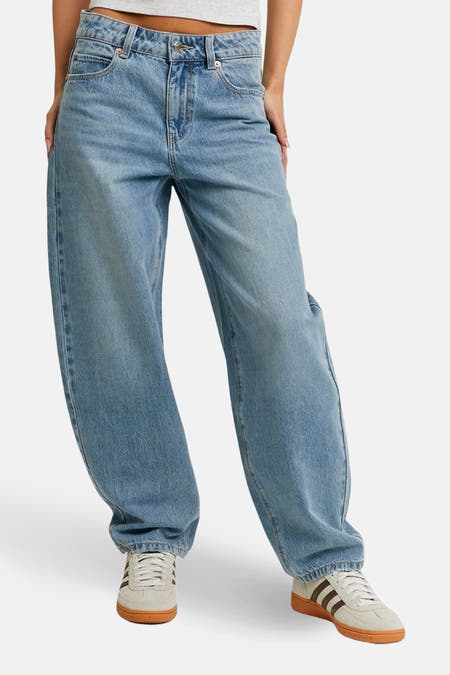 Lichtblauwe denim jeans special fit van TALLY WEIJL, met een losse pasvorm en witte sneakers met bruine accenten.
