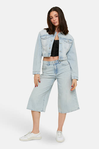 Shorts en denim bleu clair de TALLY WEIJL, associés à un haut noir et une veste en denim.