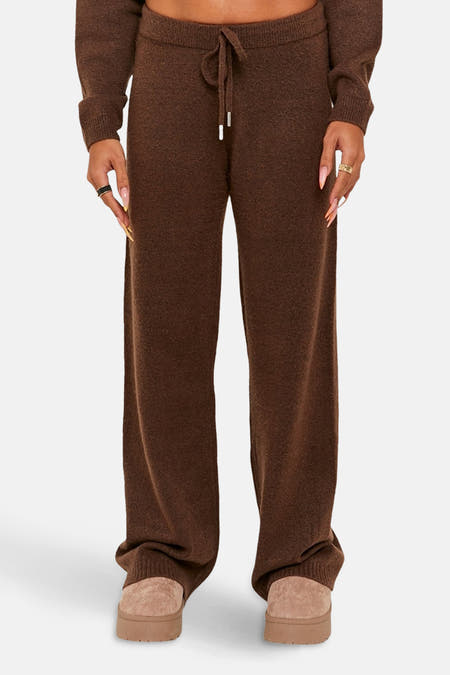 Pantalon marron de TALLY WEIJL, avec une ceinture et des jambes larges, associé à des pantoufles beige.