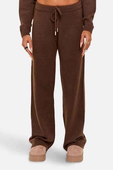 Pantalon marron de TALLY WEIJL, avec une ceinture et des jambes larges, associé à des pantoufles beige.