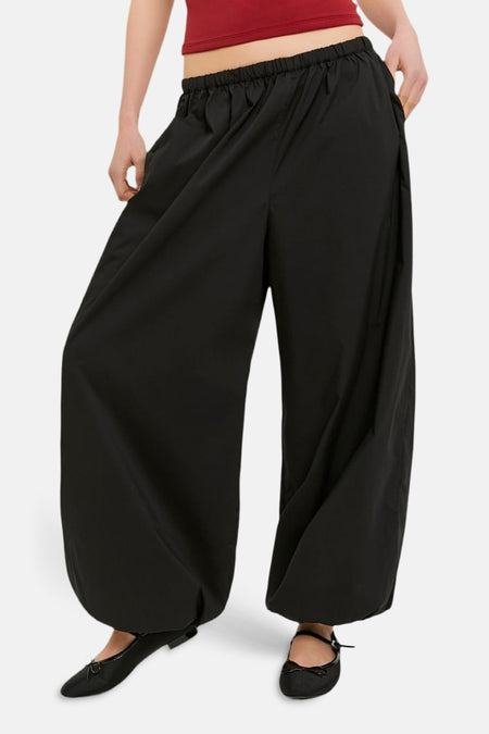 Pantalon noir de TALLY WEIJL, à jambes larges et taille élastique, combiné avec un haut rouge et des ballerines noires.