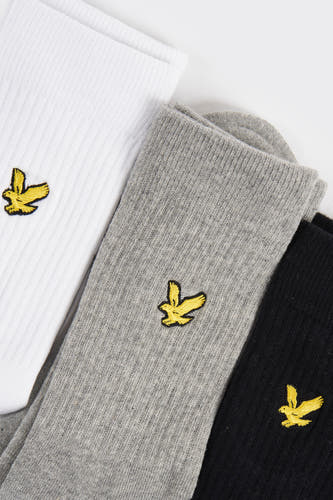 Chaussettes blanches de Lyle & Scott, avec un détail de logo brodé en jaune.
