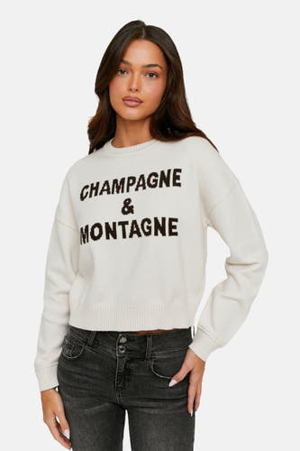 Veste écru avec col rond de TALLY WEIJL, portant l'inscription 'Champagne & Montagne', associée à un jean gris.