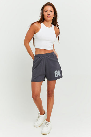 Veste grise de TALLY WEIJL, numéro 84, associée à une chemise blanche et des baskets blanches.