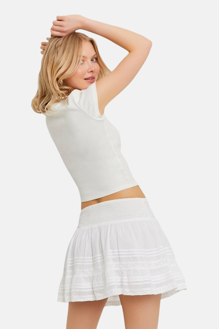 Jupe courte blanche de TALLY WEIJL avec taille smockée et bandes horizontales en dentelle.