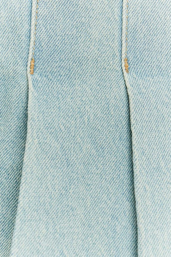 Short skirt of light blue denim from TALLY WEIJL, with stitches and folds, close-up.