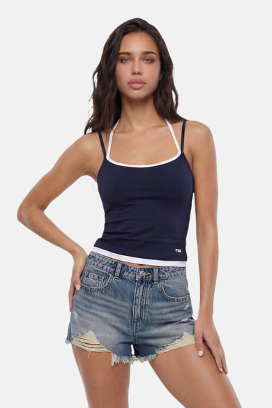 Haut bleu marine à fines bretelles de TALLY WEIJL, avec passepoil blanc et logo '7W', porté avec un short en jean.