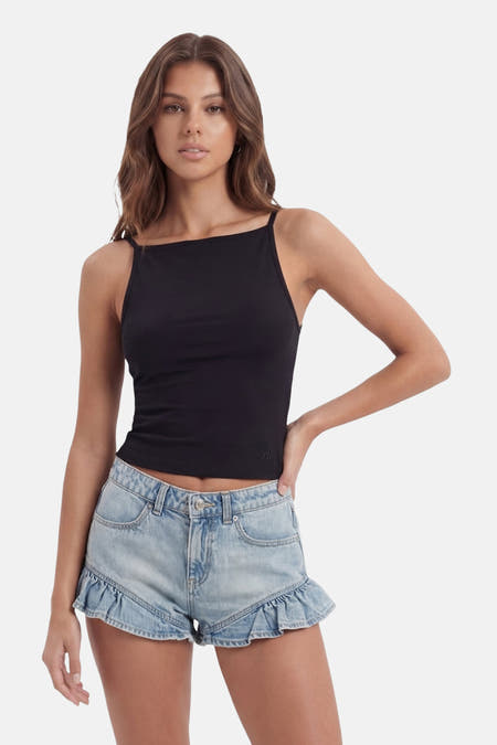 Zwart mouwloos top van TALLY WEIJL, strakke pasvorm, rechte halslijn, model in lifestyle pose met lichtblauwe jeansshorts
