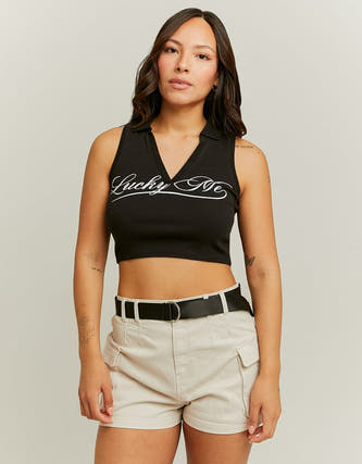 T-shirt sans manches noir de TALLY WEIJL, avec inscription, associé à des shortis beiges et une ceinture.