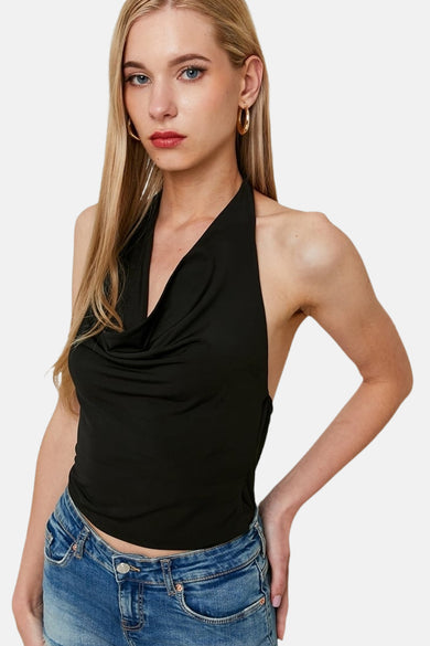 T-shirt sans manches noir de TALLY WEIJL, avec col en V et ligne de cou drapée, associé à un jean bleu.