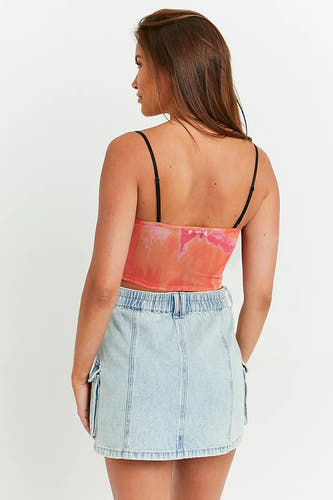 Blouse sans manches TALLY WEIJL de couleur rouge, avec un motif tie-dye rose, portée avec une jupe en denim.