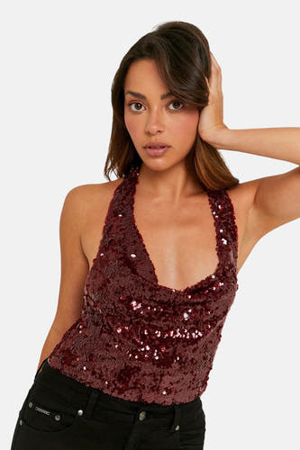 Blouse sans manches rouge de TALLY WEIJL, avec paillettes, associée à des jeans noirs.