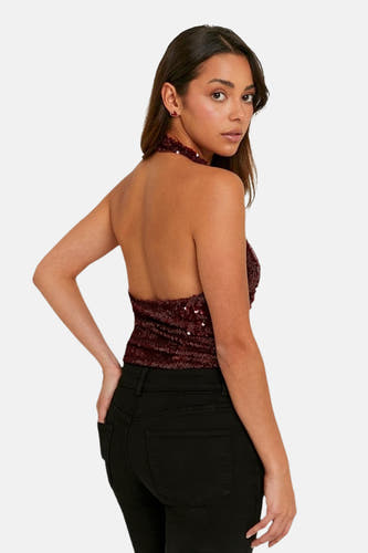 Blouse rouge à paillettes de TALLY WEIJL, associée à un jean noir.