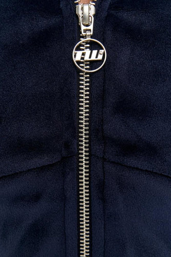 Donkerblauw velours vest met zilveren rits en logo.