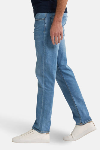 Productfoto van een persoon in een blauwe jeans en witte sneakers.