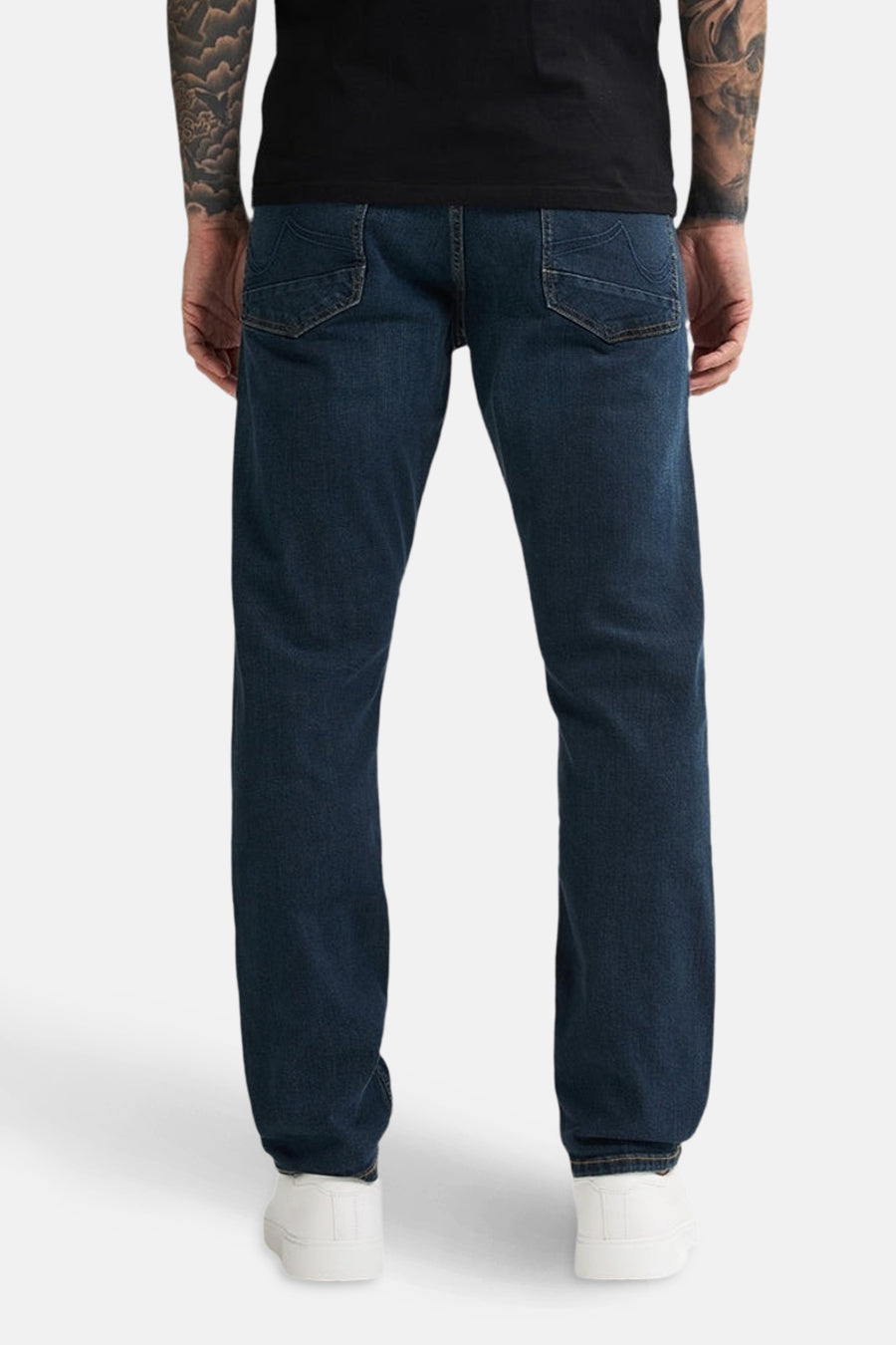 Achterkant van een man in een zwart shirt en blauwe jeans.