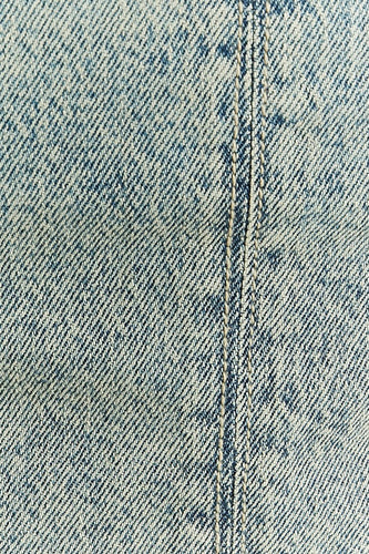 Blauwgekleurde denimstof met dubbele stiksels.