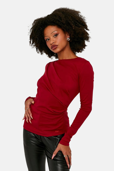 T-shirt rouge à manches longues de TALLY WEIJL, avec des plis à l'avant et porté avec un pantalon en cuir noir.