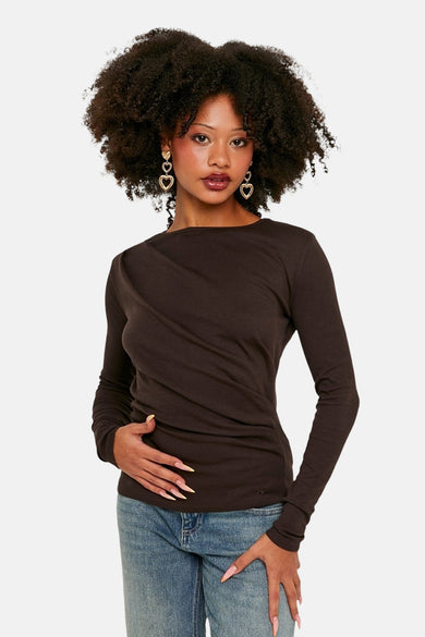 T-shirt marron à manches longues de TALLY WEIJL, avec détail drapé et associé à des jeans et des boucles d'oreilles dorées.