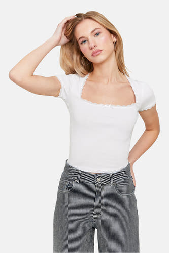 T-shirt blanc à manches courtes de TALLY WEIJL, avec des détails bordés autour de la ligne du cou, porté avec un pantalon rayé.