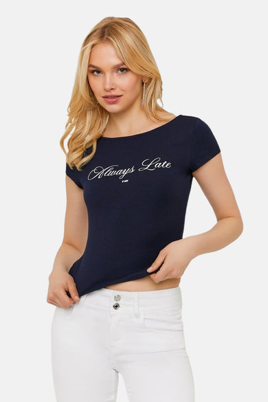 T-shirt bleu de TALLY WEIJL avec inscription blanche "Always Late", encolure bateau et manches courtes, porté avec un jean blanc.
