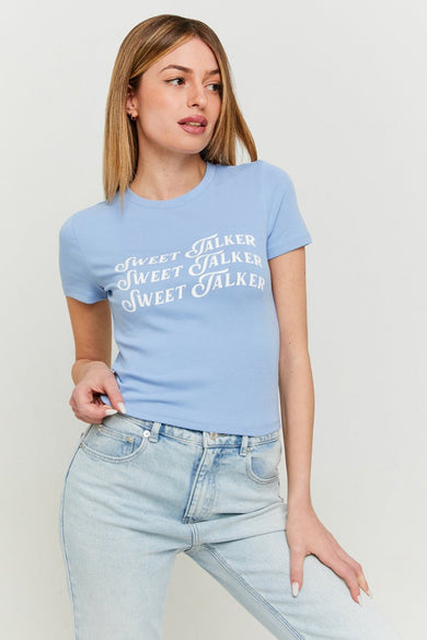 T-shirt bleu à manches courtes de TALLY WEIJL, avec le texte "Sweet Talker" dessus, associé à un pantalon en denim.