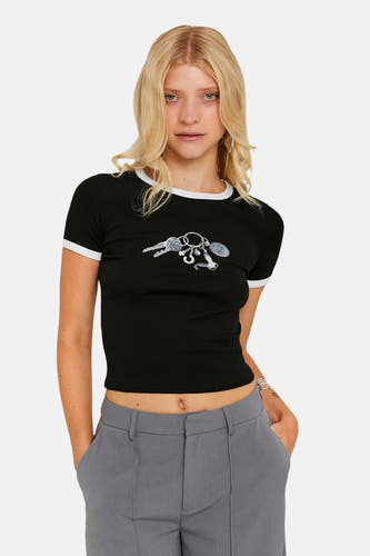 T-shirt noir à manches courtes de TALLY WEIJL, avec une impression de clés, associé à un pantalon gris.