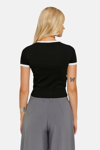 T-shirt noir à manches courtes de TALLY WEIJL, avec des accents blancs et une petite tattoo sur le bras.