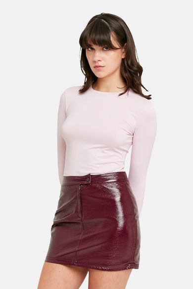 T-shirt rose à manches longues de TALLY WEIJL, porté avec une mini-jupe bordeaux brillante.