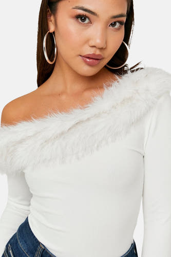 T-shirt écru à manches longues de TALLY WEIJL, avec un col en fausse fourrure blanche et de grandes boucles d'oreilles argentées.