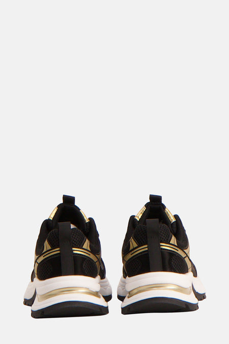 Achterkant van zwarte en gouden sneakers.