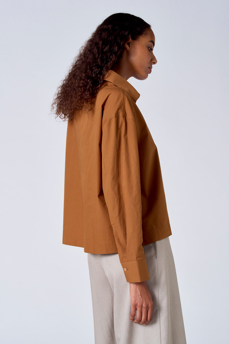 Bruine blouse met lange mouwen van SUNSET STUDIO, gezien vanaf de zijkant, gecombineerd met een beige broek.
