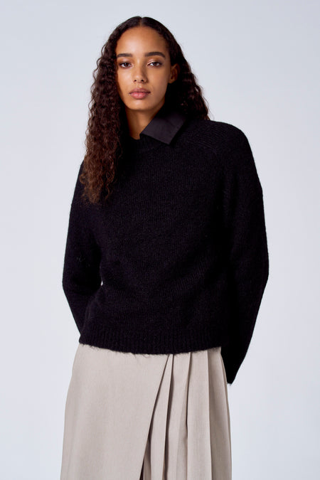 Pull-over noir avec col rond de SUNSET STUDIO, en laine et avec une jupe marron.