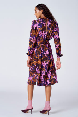 Jupe multicolore à longues manches de SUNSET STUDIO, avec un motif floral et une ceinture à la taille.